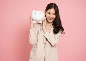 Woman holding a piggy bank over her shoulder