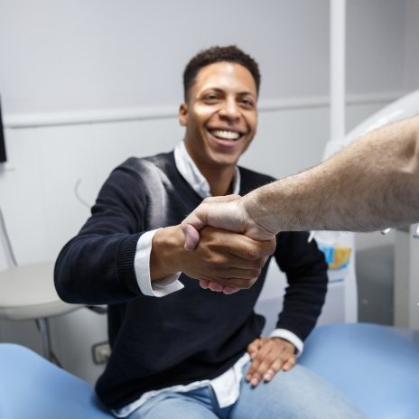 Smiling man shaking hands with his dentist