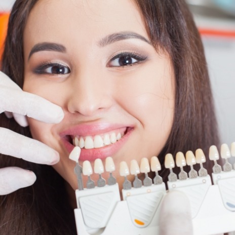 Smiling woman getting dental veneers from cosmetic dentist in Alpharetta