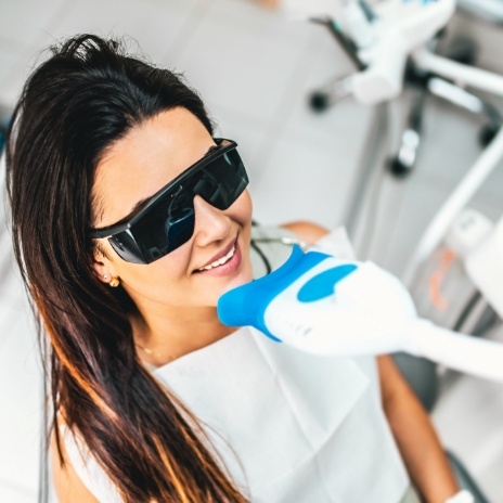 Woman getting professional teeth whitening from cosmetic dentist