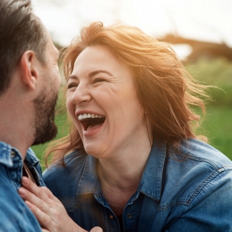 Woman laughing with man outdoors