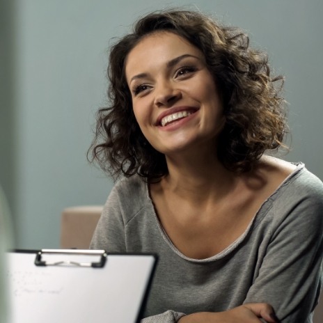 Woman smiling across from someone holding clipboard