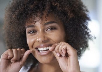 Woman smiling while flossing her teeth