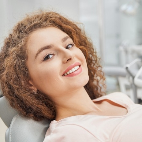 Smiling woman leaning back in dental chair