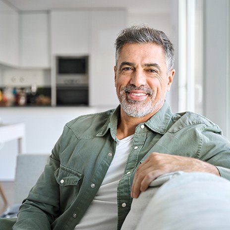 Older man sitting on couch smiling