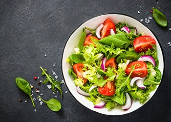 Bowl of salad with tomatoes and onions