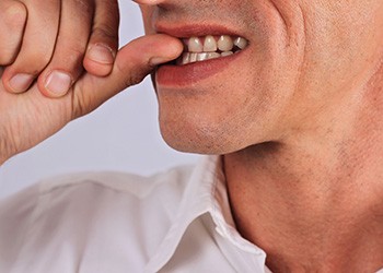 Close up of man biting his fingernails