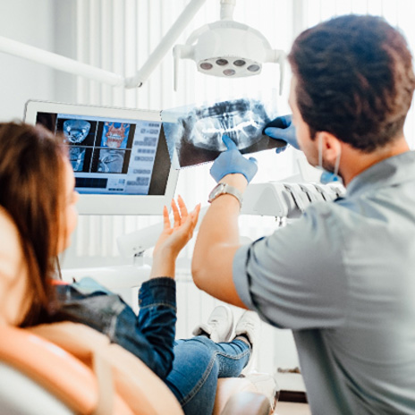 a dentist showing a patient her X-rays