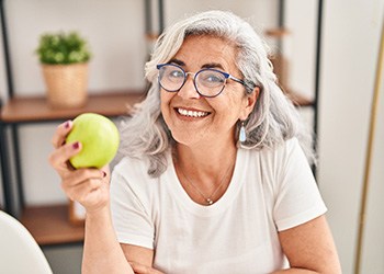 older woman holding an apple