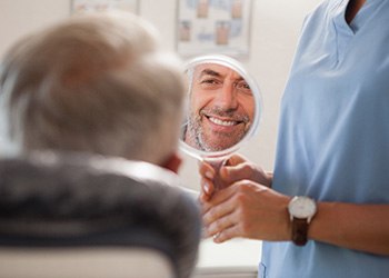 older man looking in the mirror at the dental office