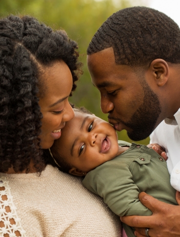 Mother and father holding and kissing their baby