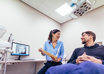 Dentist smiling at patient in treatment chair