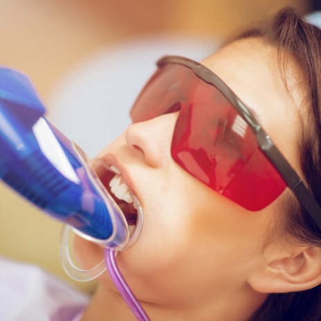 Girl in dental chair with fluoride trays on her teeth