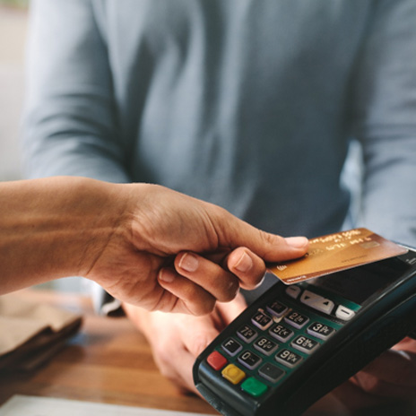 a person holding their card up to a payment device