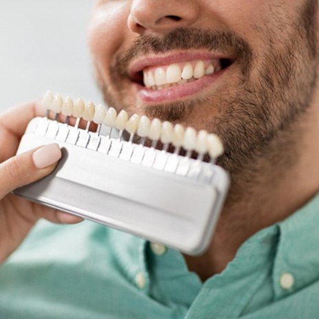 Dentist using shade scale to select veneer color