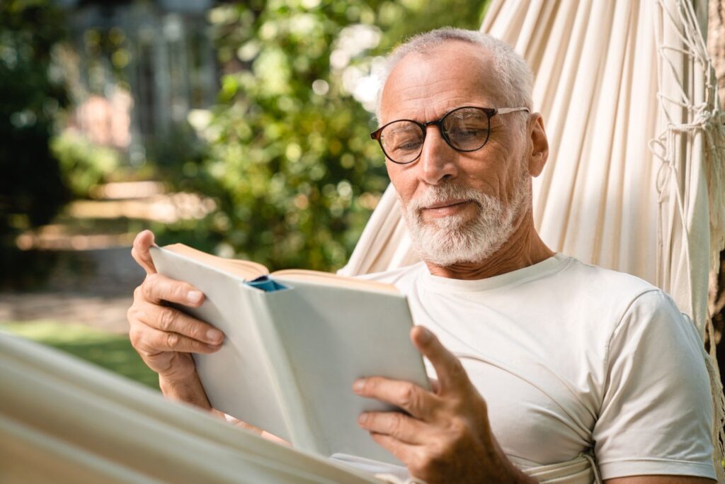 A man reading a book on a hammock